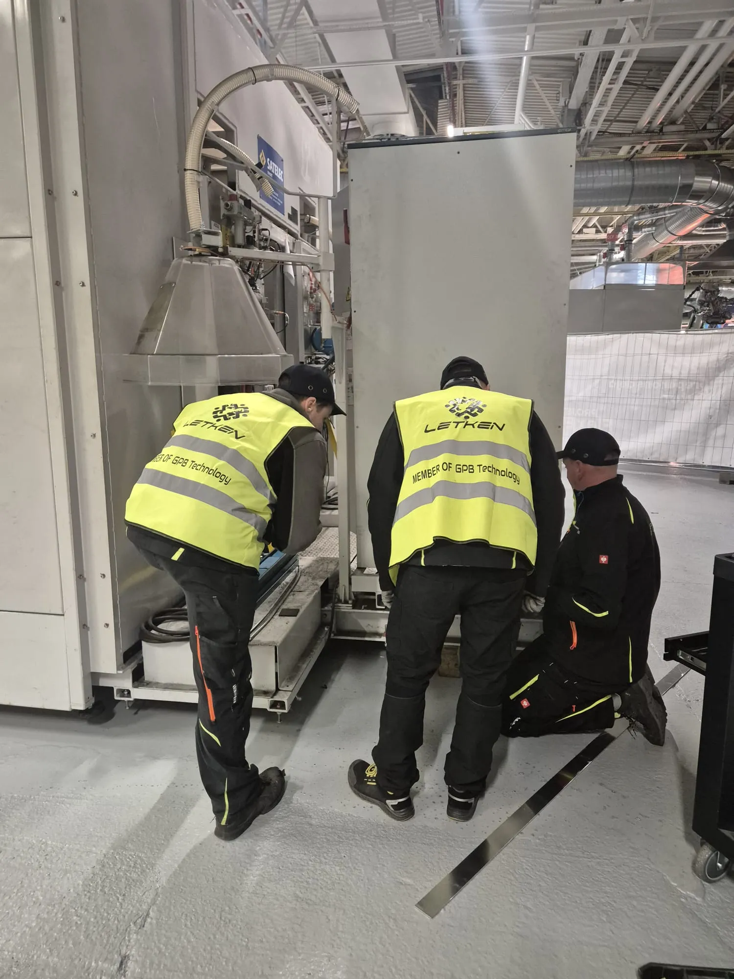Team working at the base of industrial machinery